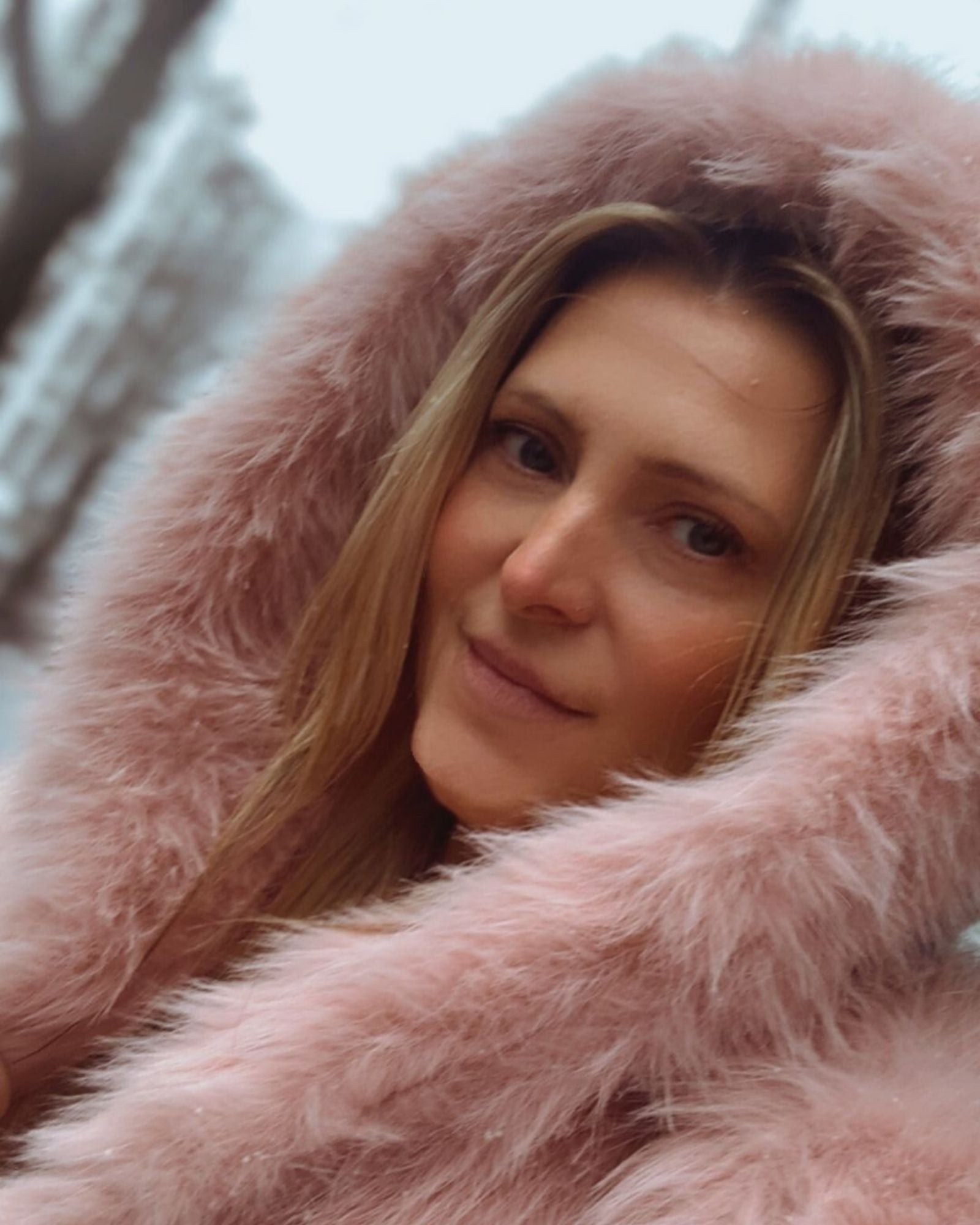 Soft pink faux fur jacket worn by model in winter setting - elegant modern quiet luxury look by LALLUVIA Onlineshop