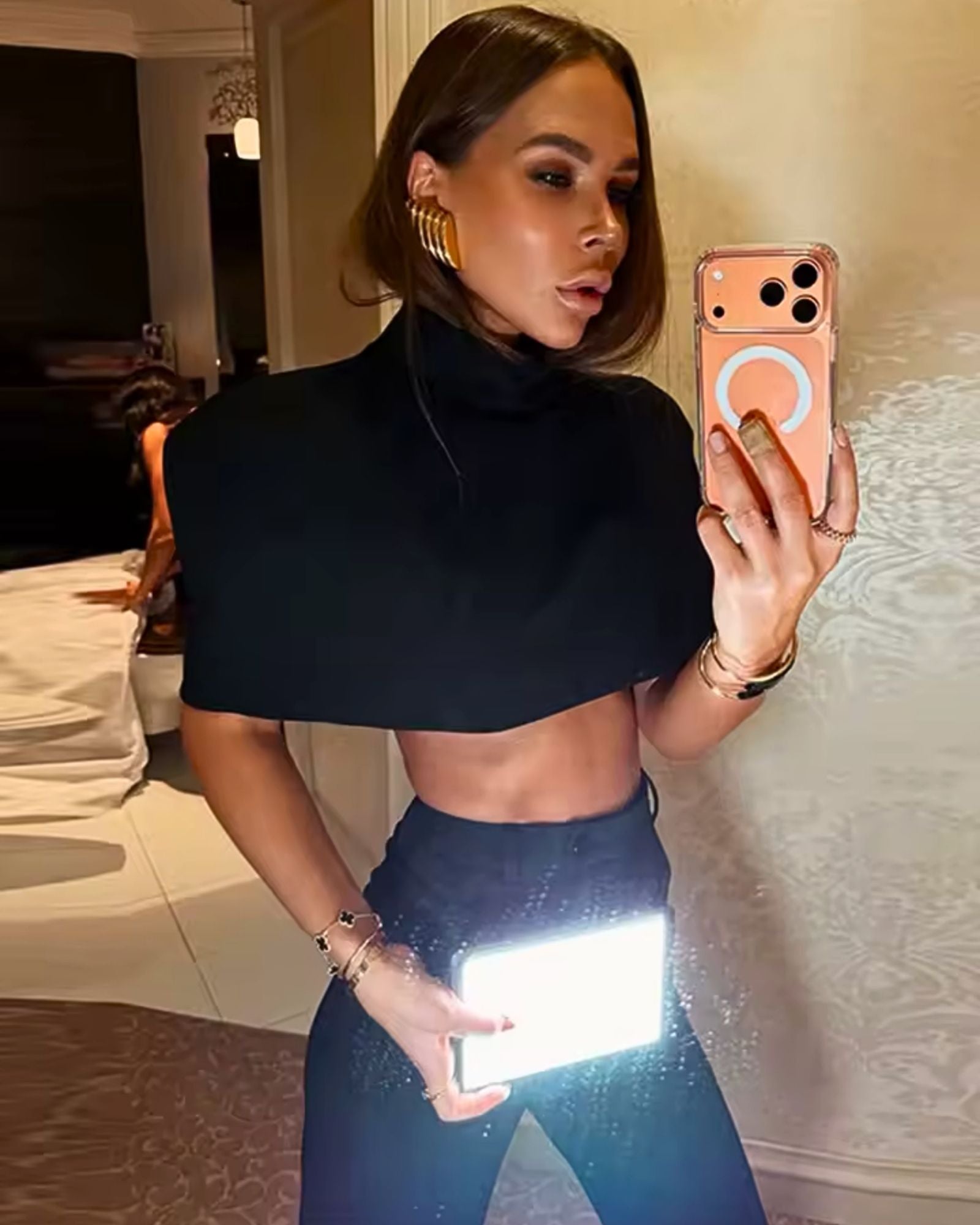 Elegant woman wearing black sculpt shoulder cape top - luxury minimalist evening outfit 